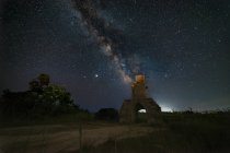 Panorama d'une vieille tour lors d'une nuit étoilée avec la voie lactée — Photo de stock