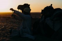 Uomo con un cammello nel deserto — Foto stock