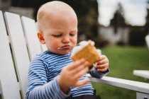 Close up of young boy eating smores with string of melted marshmallows — Stock Photo
