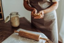 Woman making dough with rolling pin on table at kitchen — Stock Photo
