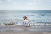 Chica jugando en el agua en la playa divertirse - foto de stock