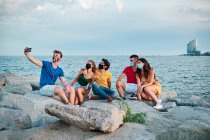 Група молодих людей в масці для обличчя від коронавірусу на пляжі — стокове фото