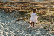 Petite fille s'amuser sur la plage — Photo de stock