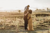 Casal feliz com uma criança na praia — Fotografia de Stock