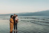 Coppia felice con un bambino sulla spiaggia — Foto stock