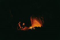 Jovem casal em frente ao acampamento de fogo à noite no norte da Califórnia. — Fotografia de Stock