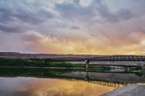 Ponte sobre o rio e pôr do sol no fundo da natureza — Fotografia de Stock