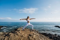 Belle femme pratiquant le yoga sur la plage — Photo de stock
