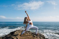 Bella donna che pratica yoga sulla spiaggia — Foto stock