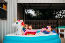 Симпатичные брат и сестра веселятся в бассейне — стоковое фото