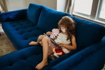 Мила маленька дівчинка з планшетом на дивані — стокове фото