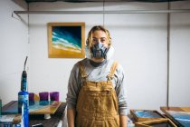 Retrato de artista de resina femenina en estudio de arte casero - foto de stock