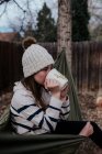 Девушка-подросток, сидящая в гамаке и пьющая из кружки — стоковое фото