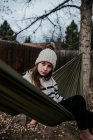 Дівчина сидить на гамаку на задньому дворі — стокове фото
