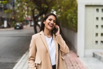 Красива іспаномовна жінка розмовляє по телефону на вулиці — стокове фото