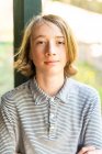 Откровенный портрет мальчика-подростка, улыбающегося с волосами длиной плеч — стоковое фото