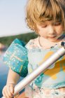 A little girl standing in a kayak attempting to paddle — Stock Photo