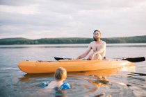 Un padre y un hijo disfrutando de un caluroso día de verano en el lago juntos - foto de stock