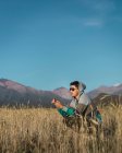 Молодий чоловік сидить у полі поруч з горами Анд — стокове фото