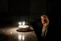 Маленькая девочка загадывает желание перед тем, как задуть свечи — стоковое фото