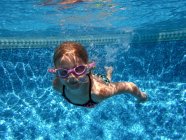 Mädchen schwimmt mit Schutzbrille unter Wasser — Stockfoto