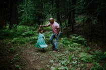 Pai e filha dançando no meio da floresta — Fotografia de Stock