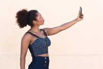 Чорна жінка робить селфі зі своїм мобільним телефоном — стокове фото