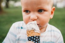 Weißes Baby mit blauen Augen isst Eis mit schmutzigem Mund — Stockfoto