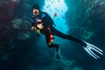 Subacqueo esplorare grotta presso la grande barriera corallina — Foto stock