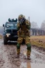 Ukraine modern soldier patrolling with a machine gun in his hands and an armored car — Foto stock