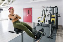 Athletic woman exercising abs on machine in gym — Stock Photo