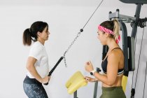 Reife Frau trainiert mit ihrem Personal Trainer im Fitnessstudio — Stockfoto