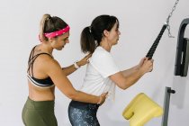 Reife Frau mit ihrem Trainer trainiert im Fitnessstudio — Stockfoto