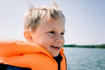 Portrait of happy young boy sat in a boat in summer in Sweden — Stock Photo