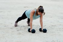 Giovane donna che fa allenamento con i pesi in ambiente urbano. — Foto stock