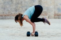 Giovane donna che fa posizioni yoga in ambiente urbano. — Foto stock
