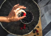 Bleuets et framboises un beau fond avec lumière naturelle. — Photo de stock