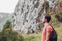 A man with backpack hiking in the mountains — Stock Photo