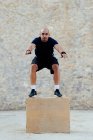 Homem praticando crossfit pulando em uma caixa pliométrica. — Fotografia de Stock