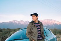 Схиляється молодий чоловік сидить в машині милуючись гірським ландшафтом — стокове фото