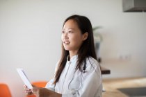Jovem asiático feminino médico com relatório em uma prática — Fotografia de Stock