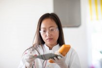 Científico femenino con muestra y herramienta en un laboratorio - foto de stock