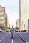Front view of a young teen with backpack skateboarding in city street — Stock Photo