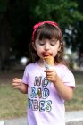 Petite fille mangeant de la crème glacée au chocolat witn no bad vibes t-shirt — Photo de stock