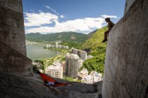 View to man on rock climbing mountain hammock with beautiful lagoon — Stock Photo