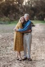 Portrait of adult woman and senior father embracing at park — Stock Photo