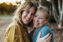 Close up portrait of adult mother and senior mother smiling outside — Stock Photo
