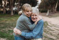 Close up portrait of senior adult couple hugging in forest — Stock Photo
