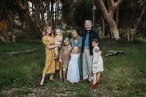 Ritratto di famiglia multigenerazionale che sorride e si abbraccia sul campo — Foto stock