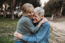 Nahaufnahme Porträt eines erwachsenen Senioren-Paares, das sich im Wald umarmt — Stockfoto